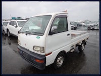 a small white truck is parked in a parking lot