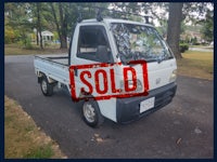 a white truck with a sold sign on it