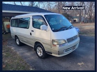 a white van is parked in front of a garage