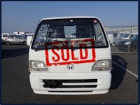 a white truck with a sold sign on it in a parking lot