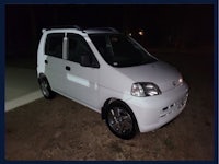 a small white car parked on the side of the road