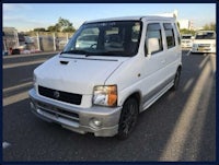 a white suzuki van parked in a parking lot