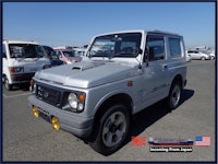 a silver suzuki samurai parked in a parking lot